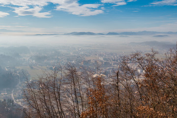 Fototapeta na wymiar Kamnik town and valley covered with translucent morning mist.