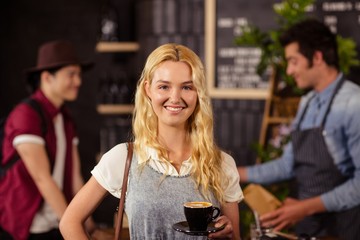 Portrait of smiling pretty customer holding cup of coffee 