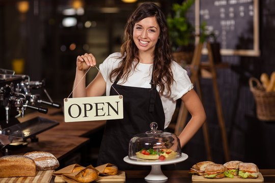 Pretty waitress holding a open sign