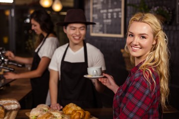 Smiling waiter serving a coffee to a customer