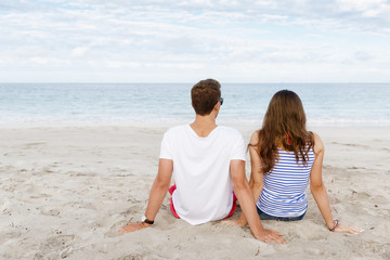 Romantic young couple sitting on the beach