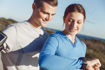 Runner woman with heart rate monitor running on beach