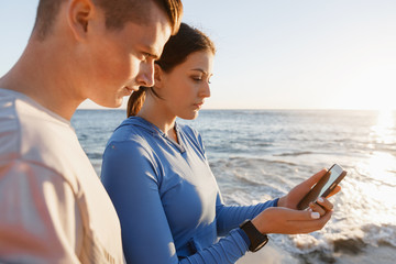 Young couple with smartphones outdoors