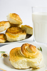 Breakfast with cinnamon buns and glass of milk on a white background. Homemade baking.