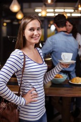 Smiling woman holding white cup