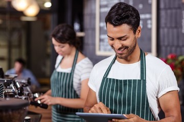 Smiling barista using tablet