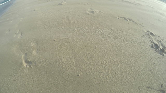 Footprints in sand on windy beach