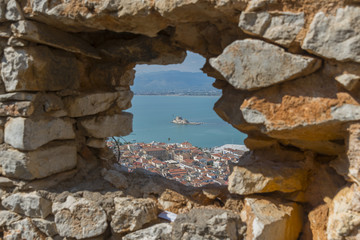 Looking at the old city of Nafplio, Greece through a stone windo