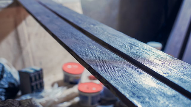 Process of painting the pine wood boards with the brush and the purple paint