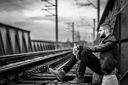 Man with beard sitting on the railway