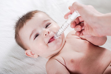 Doctor gives some medicine to a little baby.