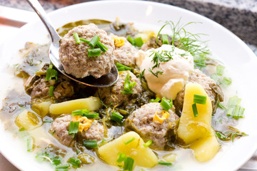 Sorrel soup with meatballs .