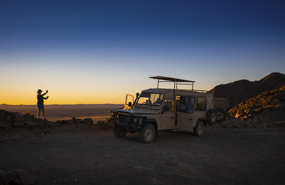 Africa, Namibia, Namib Desert, vehicle and female tourist in Kulala Wilderness Reserve