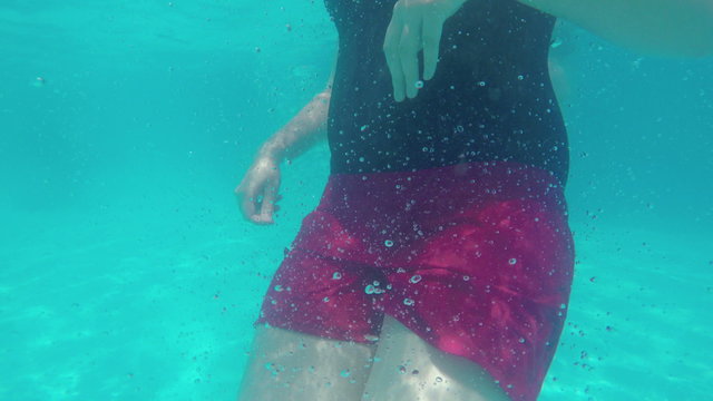 Woman doing somersault underwater in swimming pool