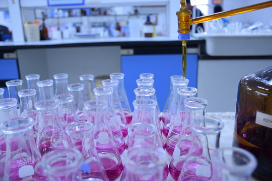Scientist Working At Laboratory ,Titration  is a common laboratory method of quantitative chemical analysis to determine the concentration of an identified analyte 
