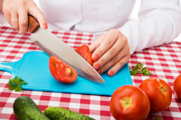 Chef cuts fresh tomato