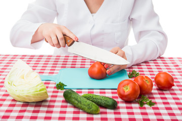 female chef cuts tomato