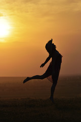 silhouette of a beautiful girl jumping in the sunset