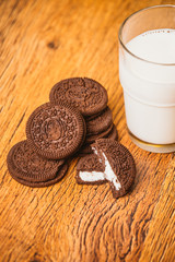 some dark glass of milk and cookies on a blurred background