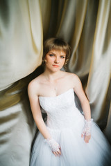 Fototapeta na wymiar portrait a beautiful young bride on the background of fabrics