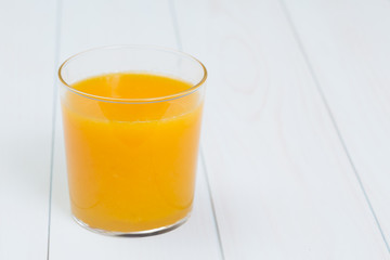 Orange juice and slices of orange on blue table