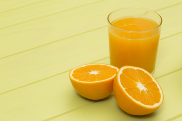 Orange juice and slices of orange on green table