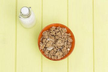 Granola in a bowl with milk on a wooden table, muesli