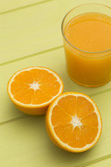 Orange juice and slices of orange on green table