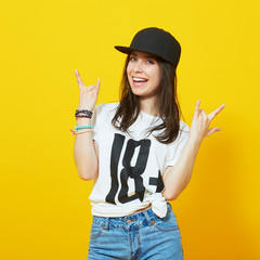 girl in hip-hop clothes making a hand sign