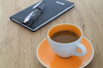 Fototapeta na wymiar Coffee cup with notebook and glasses