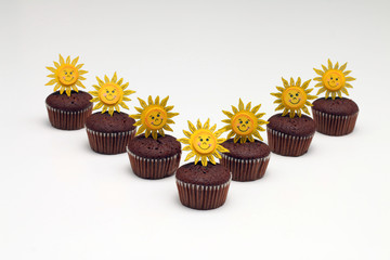 Chocolate muffins with sun decoration, isolated on white background