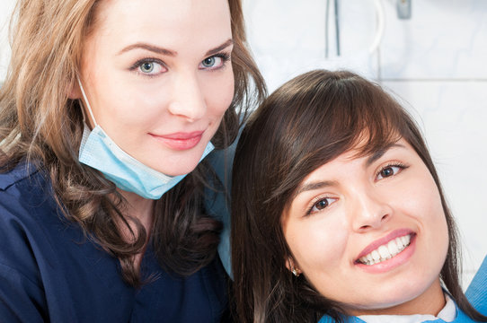 Woman dentist and patient smiling in dental office