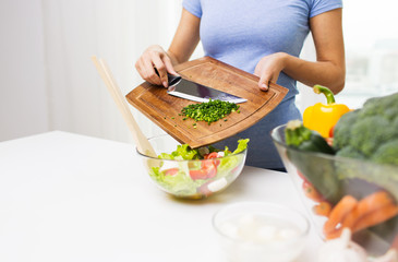 close up of woman with chopped onion cooking salad