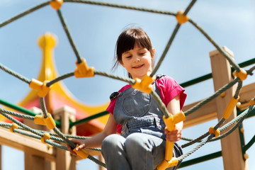 happy little girl climbing on children playground