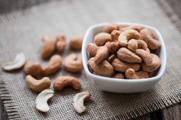 Salted cashew nuts in bowl on sackcloth