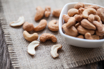 Salted cashew nuts in bowl on sackcloth