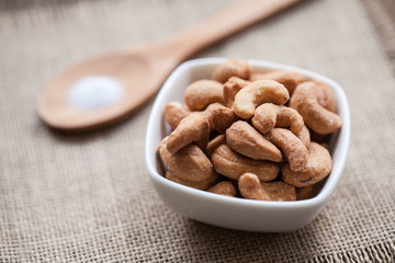 Salted cashew nuts in bowl on sackcloth