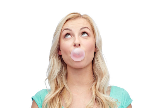 happy young woman or teenage girl chewing gum
