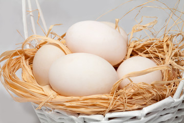 White eggs in wicker basket.