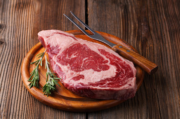 Raw ribeye steak marbled meat with  rosemary