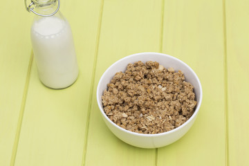 Granola in a bowl with milk on a wooden table, muesli