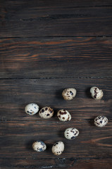 Quail eggs on a wooden table with copy space. Top view