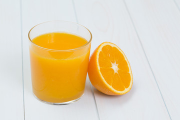 Orange juice and slices of orange on blue table