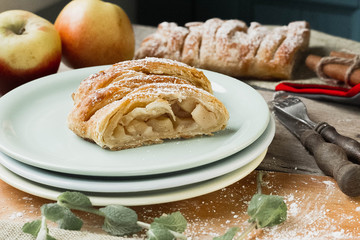 Uncooked homemade rustic apple pie preparation greased with egg yolk on white kitchen background
