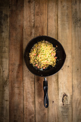  fried rice with vegetables, meat and fried eggs served on a plate with chopsticks