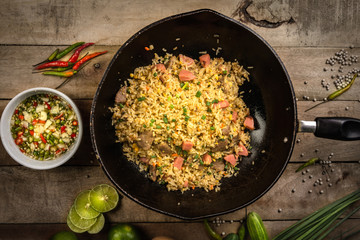  fried rice with vegetables, meat and fried eggs served on a plate with chopsticks