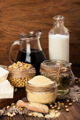 Soy products (soy flour, tofu, soy milk, soy sauce) on a wooden background. rustic style