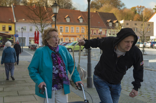 Pickpocket stealing bag from senior woman
