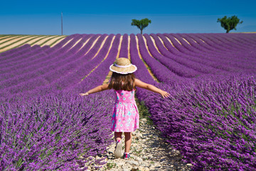Girl in pink dress walking in lavender field
