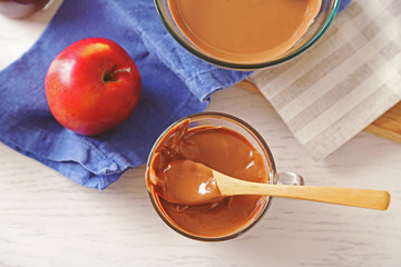 Melted chocolate on glass bowl, on wooden background